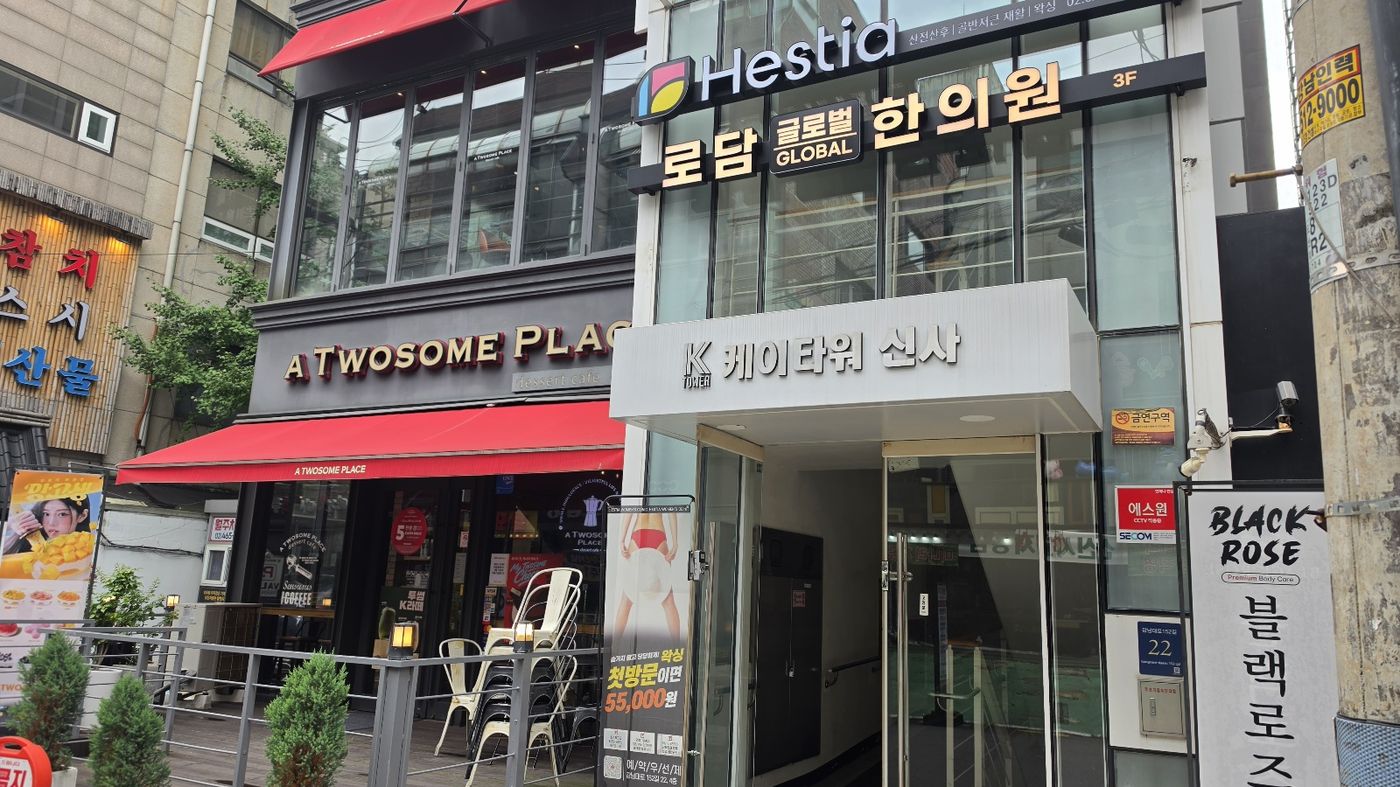 케이타워신사 B동 현관 — 투썸플레이스 옆, 「로담 글로벌 한의원 3F」 간판이 걸린 입구